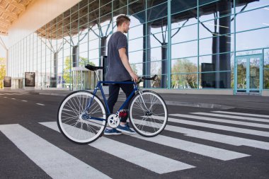  Adam yolda yürürken bir düzenleme bisiklet ile. Genç yenilikçi retro Bisiklet yaya geçidi üzerinde yürüme ile. 