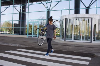  Adam bisikleti omuz üzerinde taşıyan yol adam üzerinde yürüyen bir düzenleme bisiklet ile. Genç yenilikçi retro Bisiklet yaya geçidi üzerinde yürüme ile. 