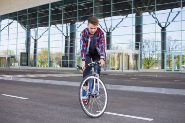 Genç adam onun sabit vites bisiklet üzerinde boş alışveriş merkezi parcking Dengeleme 