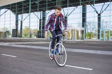 Genç adam onun sabit vites bisiklet üzerinde boş alışveriş merkezi parcking Dengeleme 