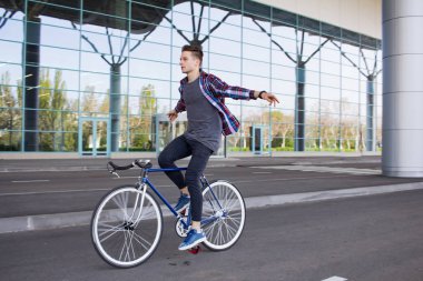 Sabit kişini bisikletçi eller olmadan spor retro bisikleti dişli. Büyük ayna pencere arka plan üzerinde