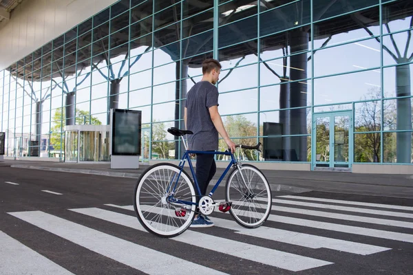 Man met een fixie fiets lopen op de weg. jonge hipster met retro fiets lopen op de oversteekplaats. — Stockfoto