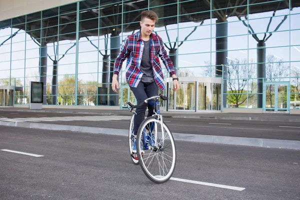젊은 남자가 빈 몰 parcking에 그의 고정된 기어 자전거에 균형 — 스톡 사진