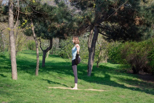 O tânără care face exerciții de yoga în parcul orașului de vară . — Fotografie, imagine de stoc