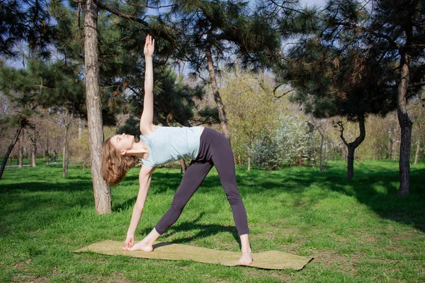 Genç kadının yaz Şehir Parkı yoga egzersizleri yapması. — Stok fotoğraf