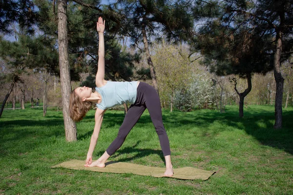 Genç kadının yaz Şehir Parkı yoga egzersizleri yapması. — Stok fotoğraf