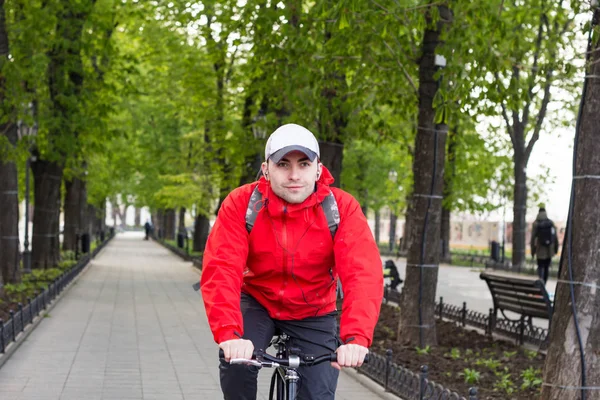 Portrét mladého muže v červené bundě, jízda na kole — Stock fotografie