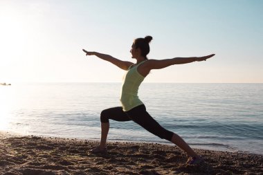 kum, sabah deniz ya da okyanus zemin üzerine karışık fitness yarış Asyalı kadın yoga poz sabah sahilde güzel kadın pratik fitness egzersiz