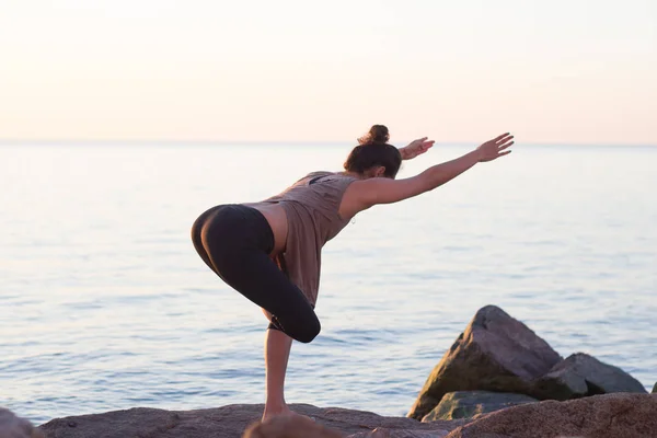 Фитнес смешанная раса азиатская женщина в позе йоги на утреннем пляже, красивая пригодная женщина практиковать фитнес Exrxise камни, утреннее море или океан фон — стоковое фото