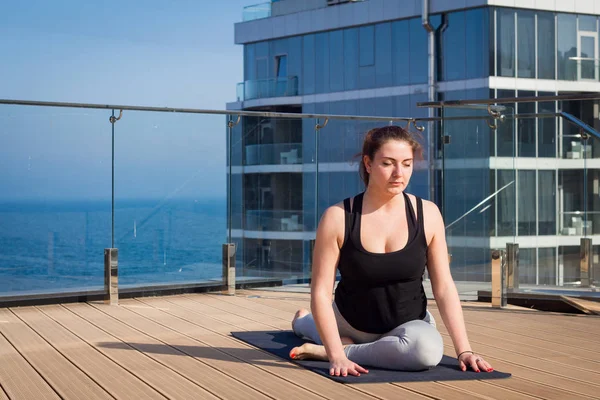 스포츠 여자 요가 매트에 나무 바닥 스탠드 호텔 지붕에 스트레칭 요가 운동을 하 고 — 스톡 사진