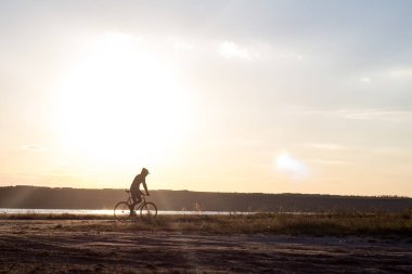 Tek başına sürücü üzerinde sabit dişli Nehri, hipster turist Bisiklet binici resimler yakınında çölde at binme yol bisikleti.