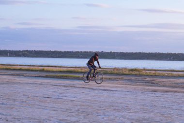 Tek başına sürücü üzerinde sabit dişli Nehri, hipster turist Bisiklet binici resimler yakınında çölde at binme yol bisikleti.