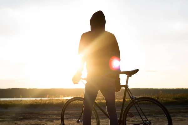 Alone rider on fixed gear road bike riding in the desert near river, hipster tourist bicycle rider pictures. — Stock Photo, Image