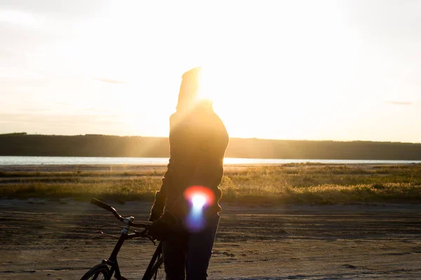 Alone rider on fixed gear road bike riding in the desert near river, hipster tourist bicycle rider pictures. — Stock Photo, Image