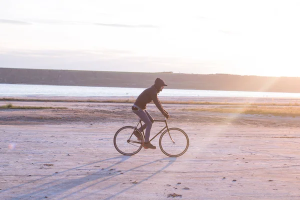 Jinete solo en bicicleta de carretera de engranaje fijo montar en el desierto cerca del río, hipster turista ciclista imágenes . — Foto de Stock