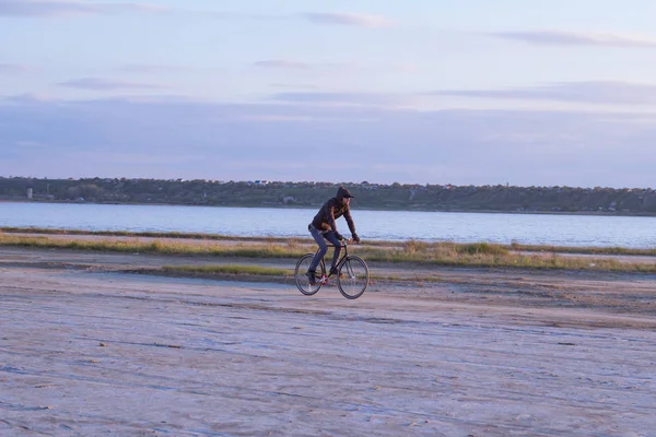 Jinete solo en bicicleta de carretera de engranaje fijo montar en el desierto cerca del río, hipster turista ciclista imágenes . — Foto de Stock