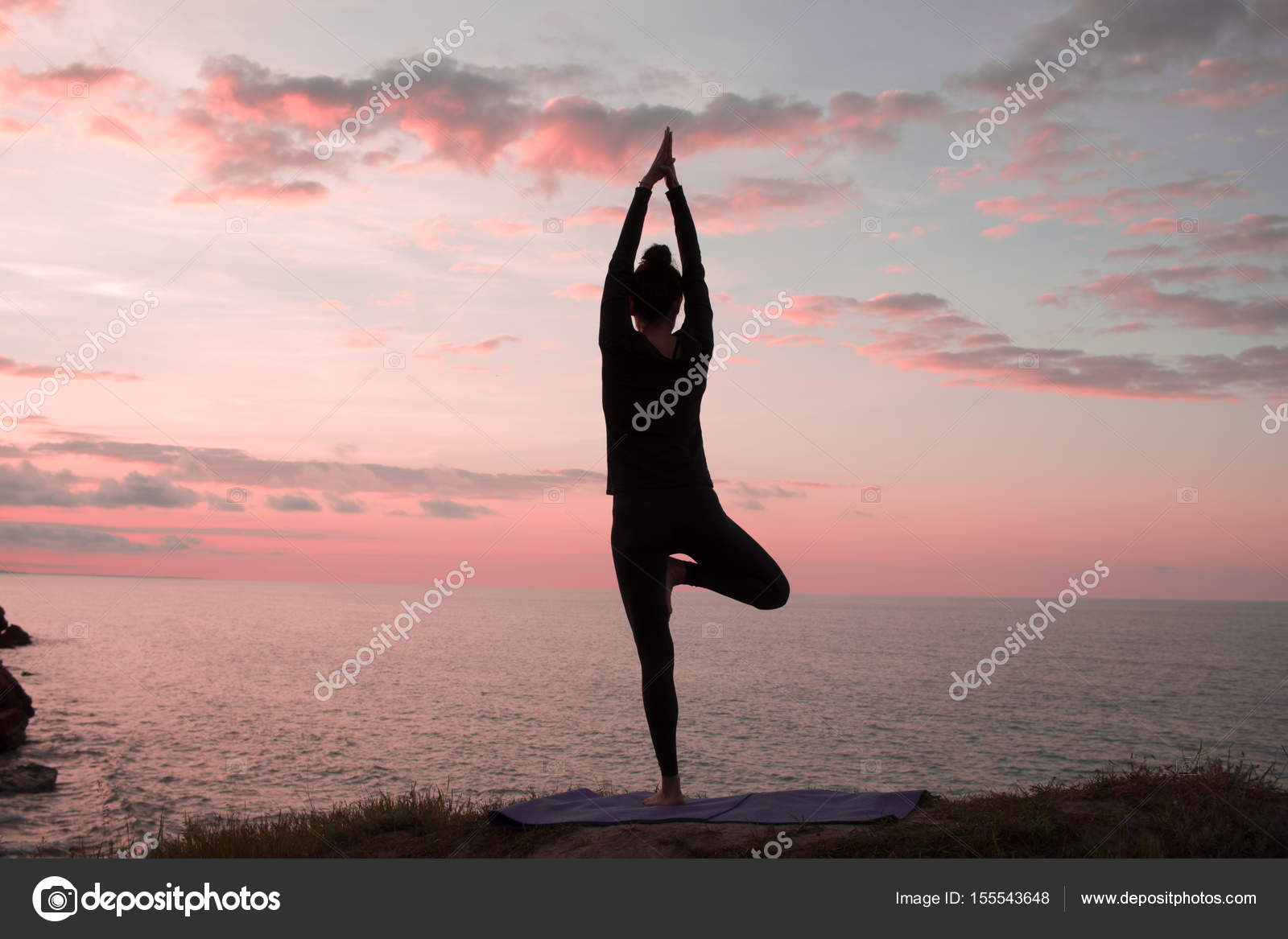 适合女人做瑜伽伸展运动户外在美丽的高山景观 女性的海和日出或日落背景培训asans 岩石上 女人的瑜伽体式的剪影 图库照片 C Serejkakovalev