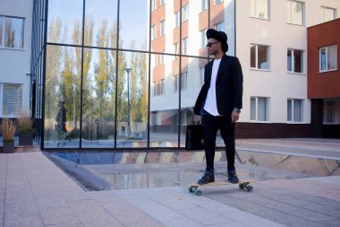 Genç, hızlı ve mobil Yöneticisi kavramı. Siyah elbiseli kaykay üzerinde komik buisinessman.