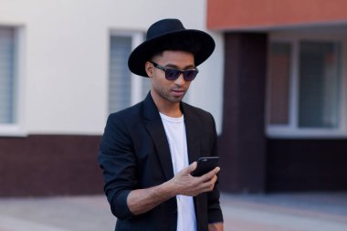 Genç mutlu erkek siyah takım elbise ve siyah şapka, modern buisinessman kavramı