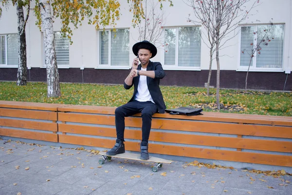 Genç, hızlı ve mobil Yöneticisi kavramı. Siyah elbiseli kaykay üzerinde komik buisinessman.