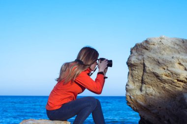 Dslr fotoğraf makinesi, genç kadınla yaz deniz ve blus arka plan gökyüzü 