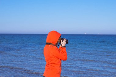 Dslr fotoğraf makinesi, genç kadınla yaz deniz ve blus arka plan gökyüzü 