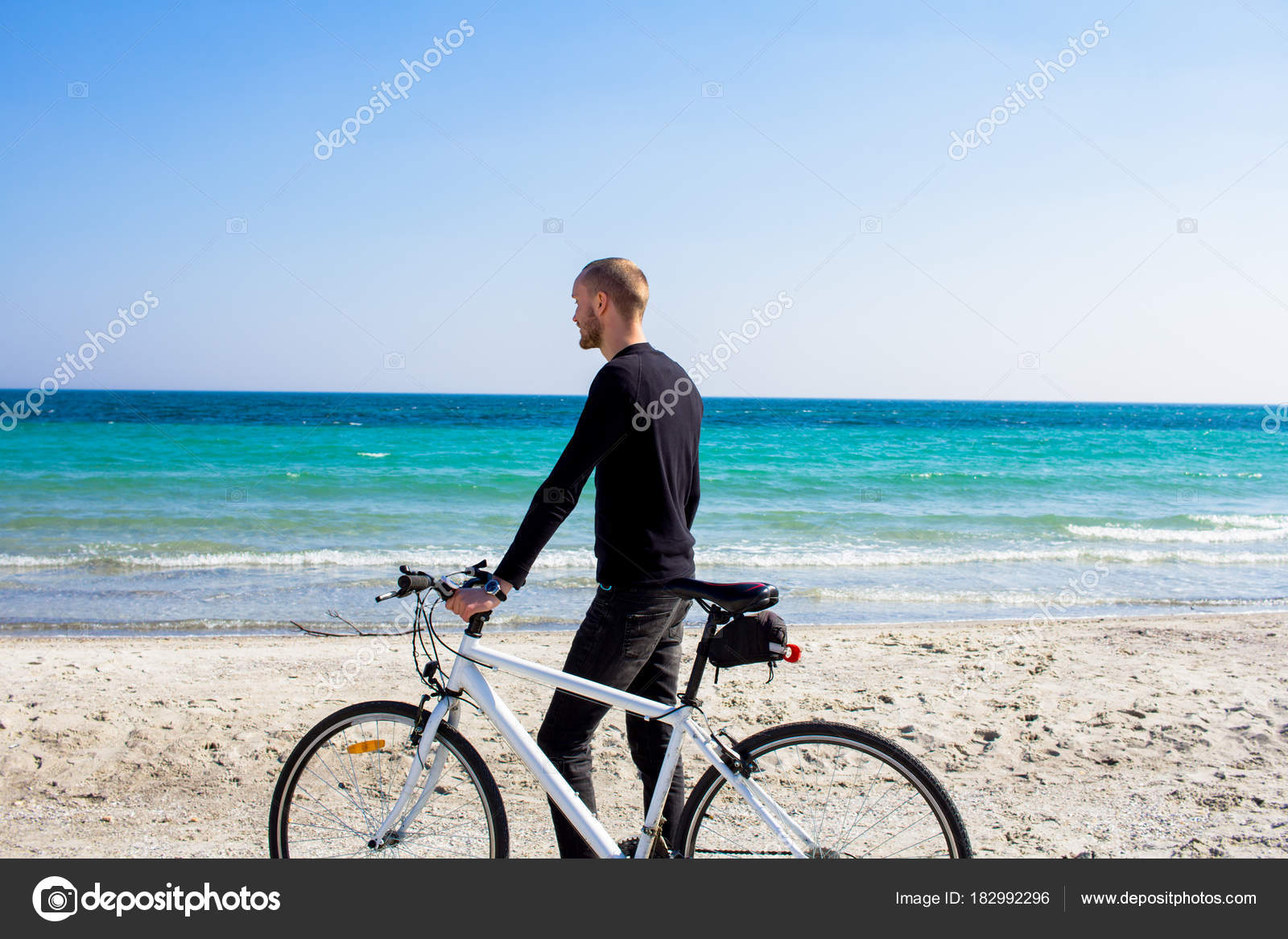 Hombre Con Bicicleta Joven Ropa Negro Playa - Foto stock gratis © serejkakovalev #182992296