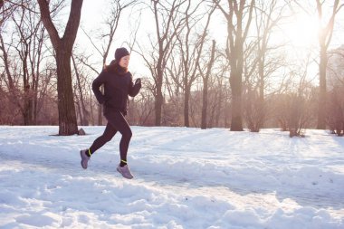 genç kadın atlet Kış parkta koşmak siyah spor kıyafetli