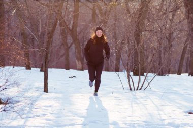 genç kadın atlet Kış parkta koşmak siyah spor kıyafetli