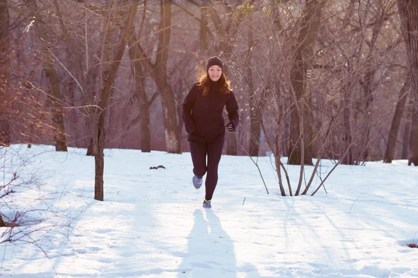 genç kadın atlet Kış parkta koşmak siyah spor kıyafetli