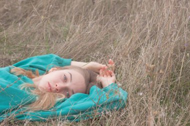 Genç kadın güzel kadın kuru otların arasında rahatlatıcı portresi, alanlara 