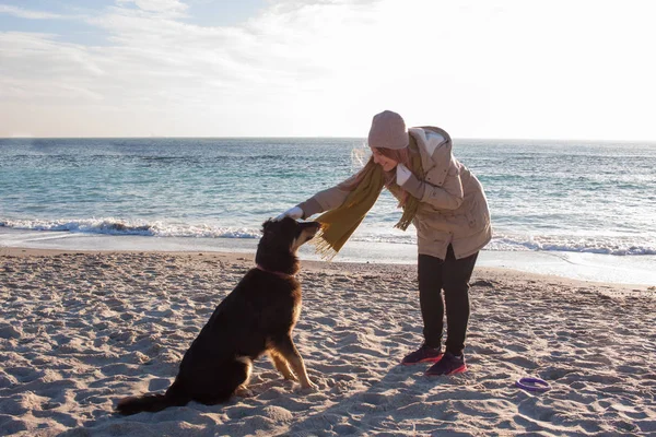 Jovem Brincar Com Grande Cão Preto Praia Dia Ensolarado — Fotografia de Stock