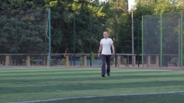 Sıra dışı görünüşlü genç erkek spor alanında esneme egzersizleri yapıyor, sporcu spor yapıyor..