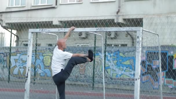 Jong Mannetje Met Ongewone Verschijning Doen Stretching Oefeningen Buiten Sportveld — Stockvideo
