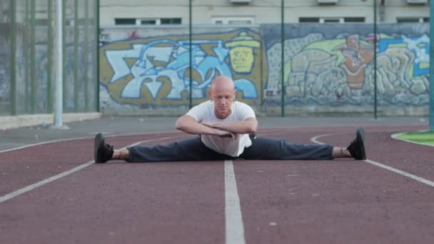 Junger Mann Mit Ungewöhnlichem Aussehen Macht Dehnübungen Freien Auf Sportplatz — Stockvideo