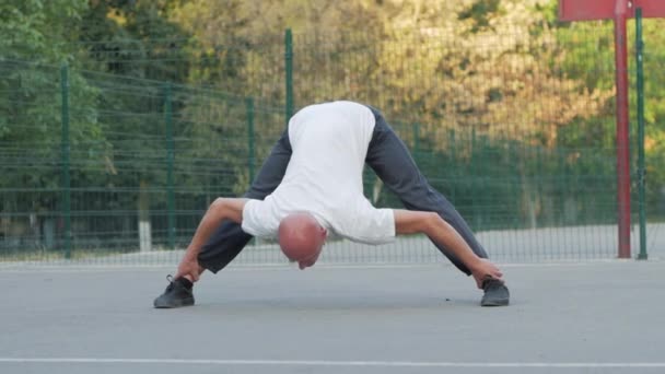 Jong Mannetje Met Ongewone Verschijning Doen Stretching Oefeningen Buiten Sportveld — Stockvideo