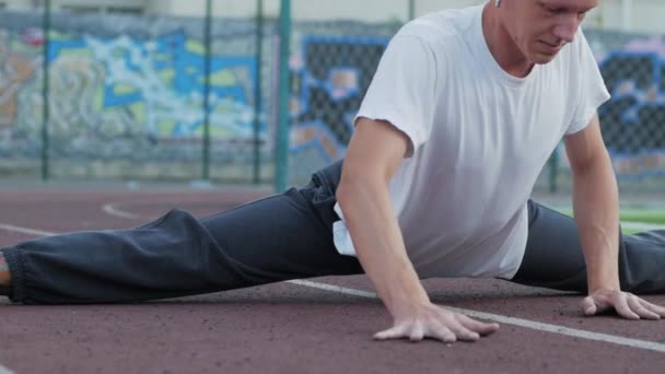 Junger Mann Mit Ungewöhnlichem Aussehen Macht Dehnübungen Freien Auf Sportplatz — Stockvideo