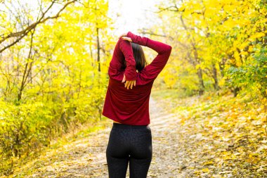 Genç mutlu kadın koşucu eğitimi güneşli sonbahar parkında