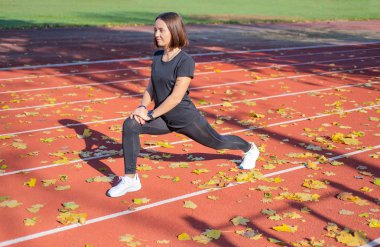 Yaz günü stadyumda genç bayan koşucu eğitimi. 