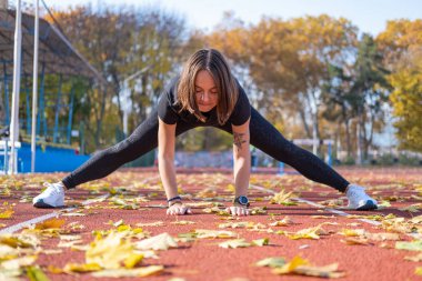 Yaz günü stadyumda genç bayan koşucu eğitimi. 