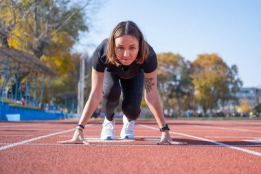 Yaz günü stadyumda genç bayan koşucu eğitimi. 