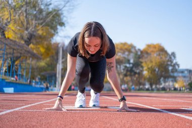 Yaz günü stadyumda genç bayan koşucu eğitimi. 