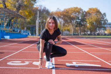 Yaz günü stadyumda genç bayan koşucu eğitimi. 