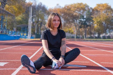 Yaz günü stadyumda genç bayan koşucu eğitimi. 