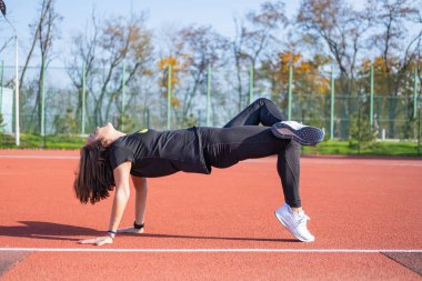 Yaz günü stadyumda genç bayan koşucu eğitimi. 