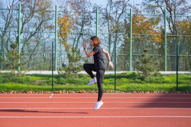 Yaz günü stadyumda genç bayan koşucu eğitimi. 