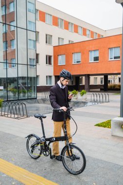 Modern bisikleti olan genç bir iş adamı.