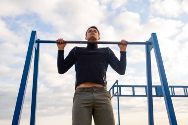 Young fit male training do exercises outdoor on the beach