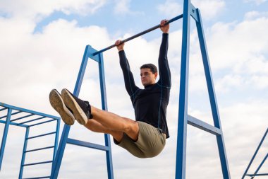 Young fit male training do exercises outdoor on the beach