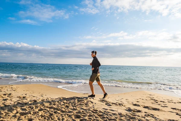 Přizpůsobit Mužské Běžec Trénink Letní Pláži Poslouchat Hudbu Proti Krásné — Stock fotografie